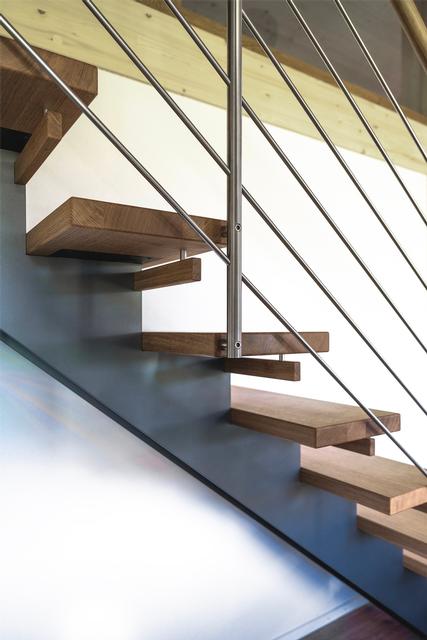 Das Bild zeigt einen Ausschnitt von einer Stahl Holmentreppe mit Holztritten