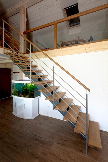 Das Bild zeigt eine Stahl Holmentreppe mit Holztritten und mit einem Handlauf aus Holz