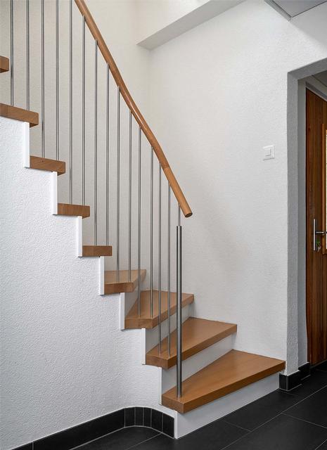 Das Bild zeigt eine schöne Holmentreppe in weiss mit Holztritten